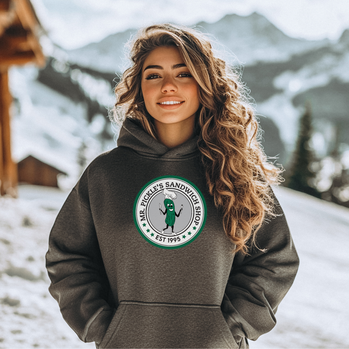 Woman wearing a hoodie with a logo in a snowy outdoor setting