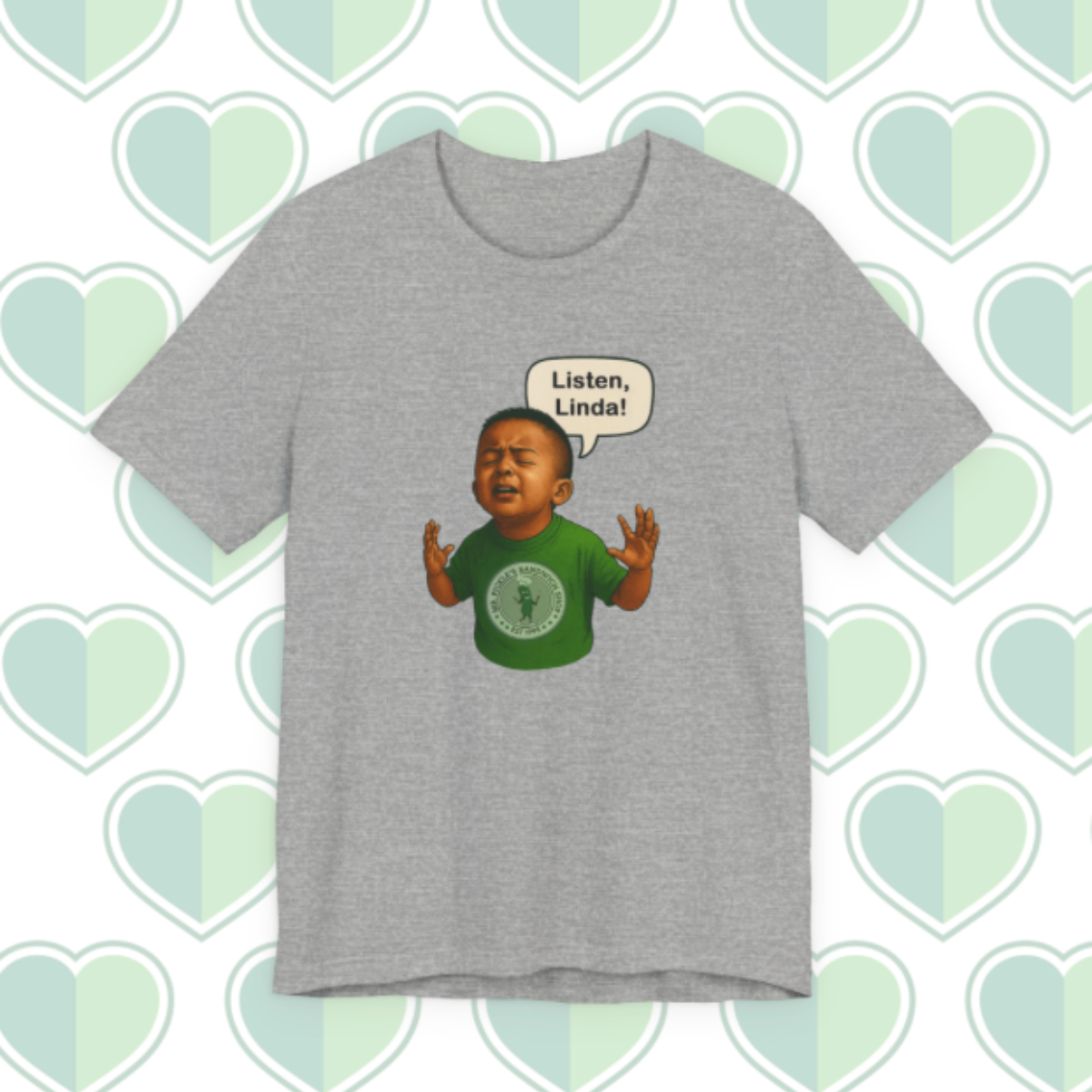 Gray t-shirt with a graphic of a child in a green shirt and a speech bubble on a heart-patterned background