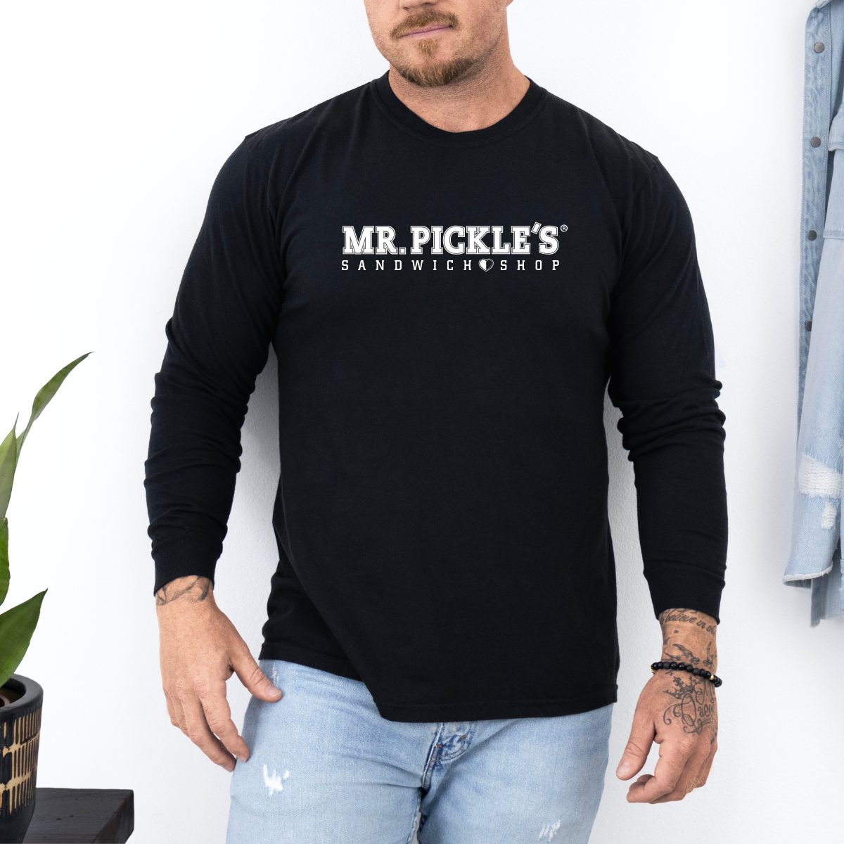 Person wearing a black long-sleeve shirt with 'Mr. Pickle's Sandwich Shop' logo.