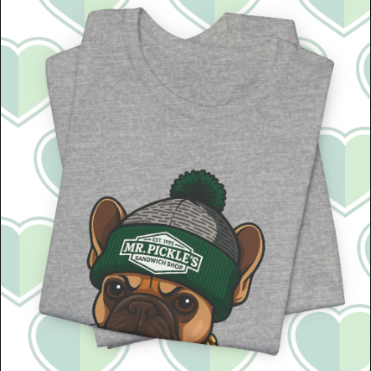 Gray t-shirt with a dog wearing a green beanie on a patterned background