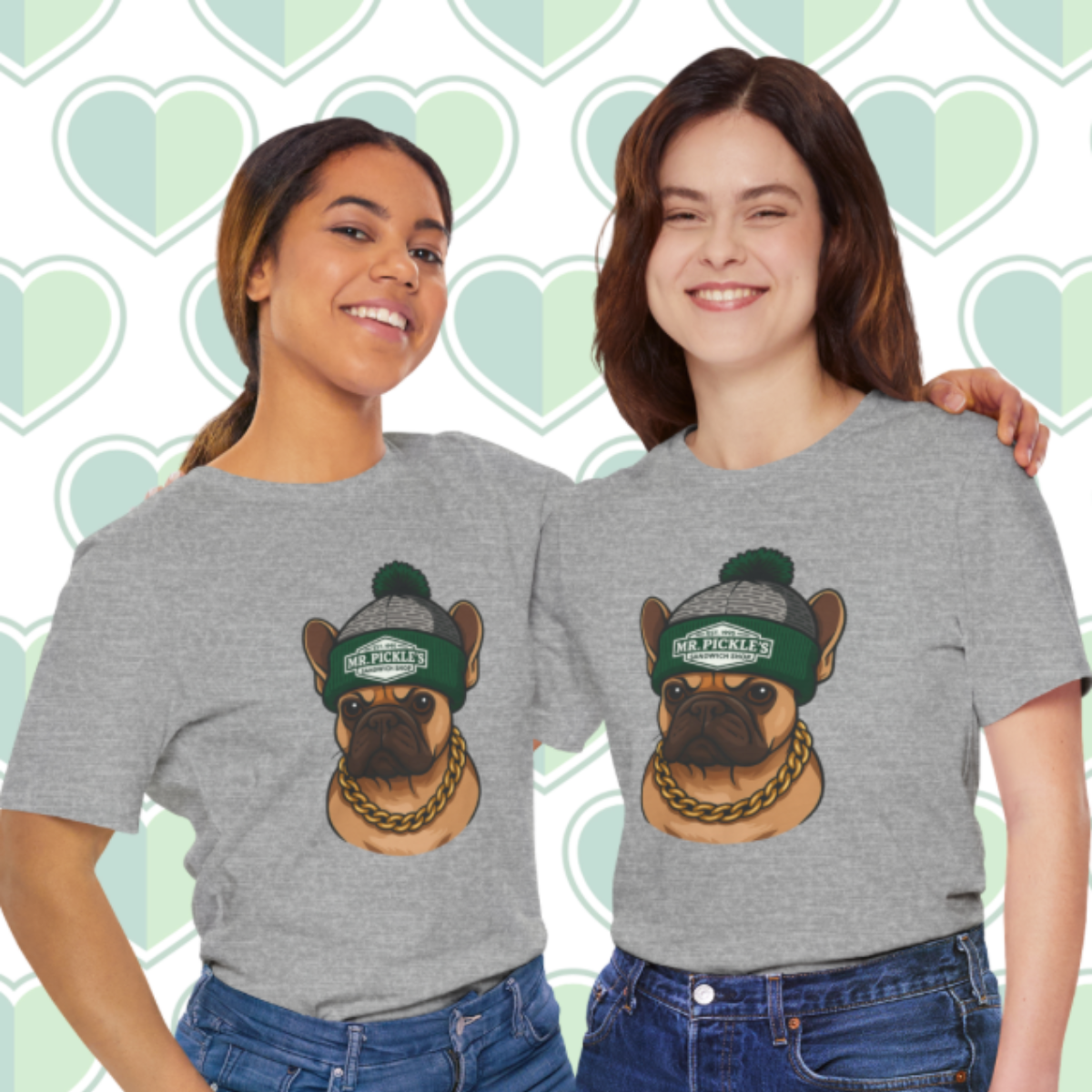 Two people wearing gray t-shirts with a dog graphic and text on a heart-patterned background