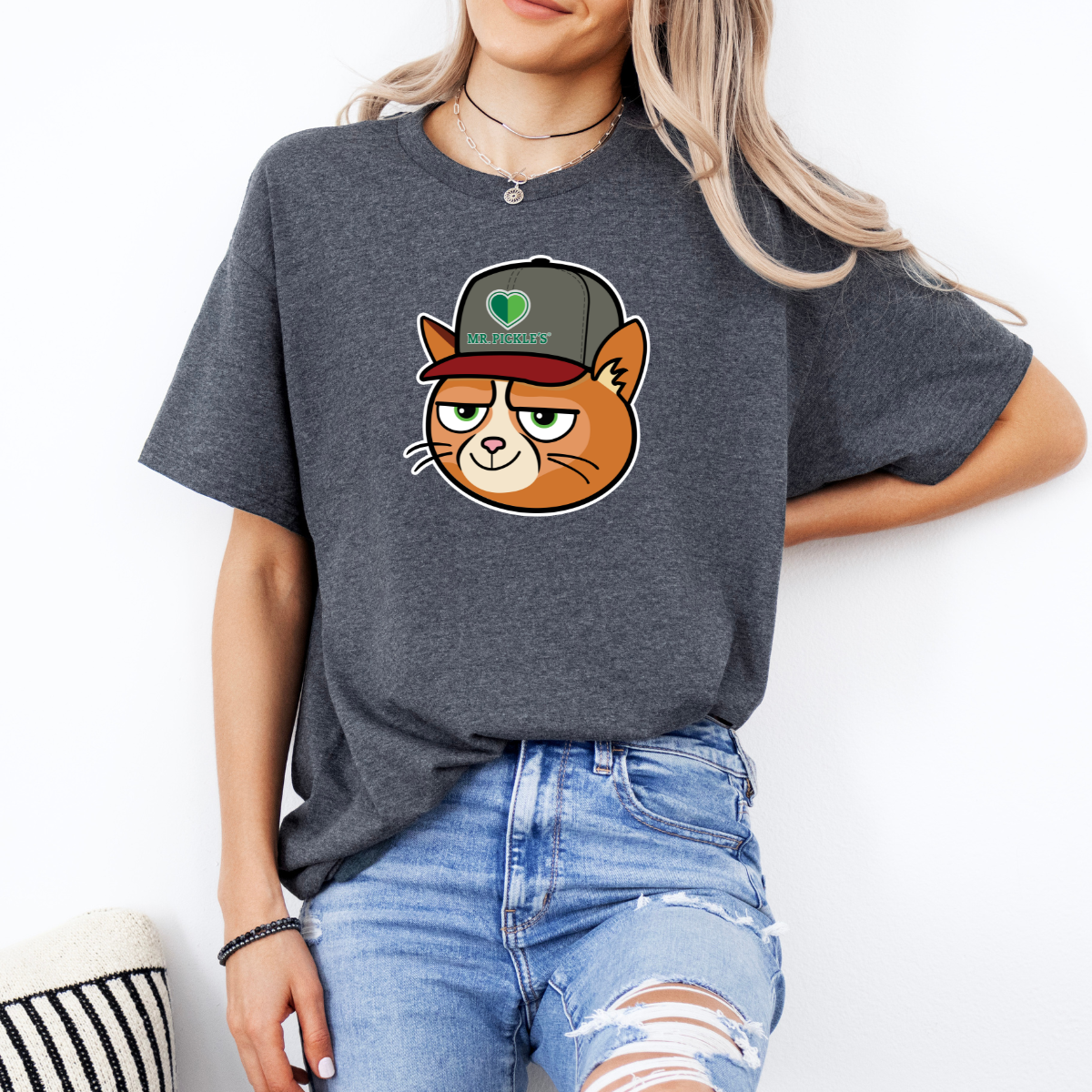 Person wearing a dark gray t-shirt with a cartoon cat design on a white background