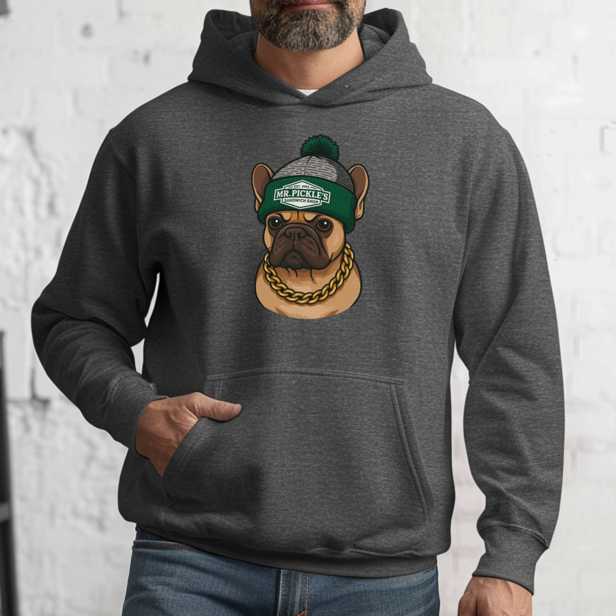 Person wearing a gray hoodie with a dog graphic and 'Mr. Pickles' text on a white brick wall background