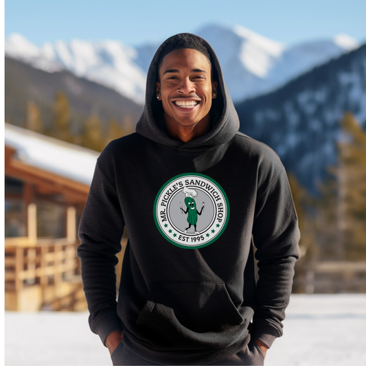 Person wearing a black hoodie with a logo in a snowy mountain setting