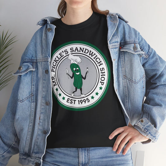 Person wearing a black t-shirt with a green and white logo and text, paired with a denim jacket.